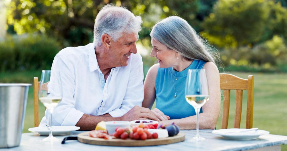 An older couple enjoying a relaxed meal outdoors